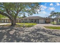 Charming single-story home with a well-maintained lawn and mature tree providing shade at 3840 Cedarwaxwing Ave, Orlando, FL 32822
