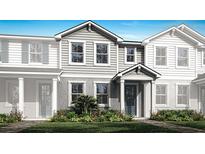 Charming two-story townhome with gray siding, manicured lawn, and colorful flower beds enhancing curb appeal at 4200 Sadler Rd, Apopka, FL 32712