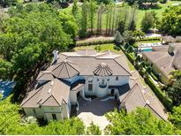 Stunning aerial view of a luxury home with a tile roof, a pool, and lush landscaping at 5067 Latrobe Dr, Windermere, FL 34786
