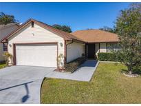 Charming single-Gathering home with a well-maintained lawn and an attached two-car garage at 6559 Grosvenor Ln, Orlando, FL 32835