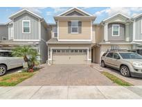 Charming two-story townhome features a brick paved driveway and attached two-car garage at 6983 Tussilago Way, Orlando, FL 32822