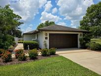 Attached garage with meticulously landscaped lawn and garden creates a welcoming curb appeal at 1 Huntley Ct, Haines City, FL 33844