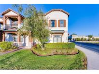 Charming two-story home featuring shutters, manicured lawn and garden with mature tree in a well-maintained community at 10765 Village Lake Rd, Windermere, FL 34786