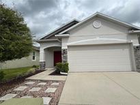 Charming single Gathering home featuring a red front door and a two car garage at 118 Hurst Ct, Deland, FL 32724