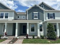 Charming two-story home featuring a covered porch and well-maintained landscaping, perfect for curb appeal at 13528 Autumn Harvest Ave, Winter Garden, FL 34787