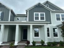Inviting two-story townhouse with a covered front porch and Craftsman-style architectural details at 13536 Autumn Harvest Ave, Winter Garden, FL 34787