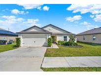 Charming single-story home with a well-manicured lawn and two car garage at 1579 Swan Lake Cir, Dundee, FL 33838