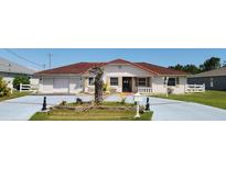Charming single-story home featuring a red tile roof and stucco exterior, with a well-manicured front yard at 39 Fellowship Dr, Palm Coast, FL 32137