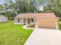 Charming single-story home boasts a well-manicured lawn, attached garage, and delightful curb appeal at 501 Mulberry St, Fruitland Park, FL 34731