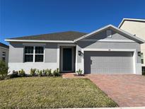 Charming single-story home features a well-maintained lawn, a brick driveway, and a neutral color scheme at 618 Duke Dr, Haines City, FL 33844