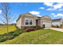 Charming single-story home with a two-car garage, lovely landscaping, and manicured lawn on a sunny day at 7536 Sw 77Th Ave, Ocala, FL 34481