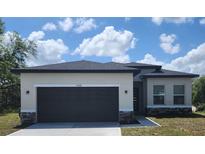 Charming single-story home featuring a gray garage door, stone accents, and a well-maintained lawn at 1408 Sarasota Way, Kissimmee, FL 34759