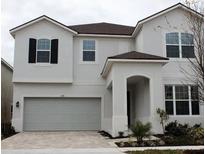 Stunning two-story home with a two car garage and manicured landscaping showcasing its curb appeal at 1790 Sawyer Palm Pl, Kissimmee, FL 34747