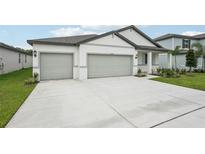 Charming single-story home with a three-car garage and a well-maintained front yard at 2352 Citrus Bloom Dr, Bartow, FL 33830