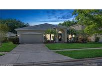 Charming single-story home featuring a manicured lawn, arched entryway, and two-car garage at 2412 Stone Cross Cir, Orlando, FL 32828