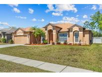 Charming home featuring desert landscaping and a two-car garage, set on a sunny day at 2721 Village Pine Ter, Orlando, FL 32833
