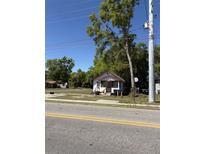 Modest single-story home with a porch, situated on a grassy lot and surrounded by mature trees at 303 E 13Th St, Apopka, FL 32703