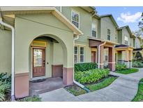 Charming exterior view of townhouse featuring landscaped bushes and a covered entryway with detailed trim at 6218 Forsythe Loop, Sanford, FL 32771