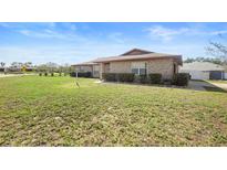 Charming single-story brick home featuring manicured front yard landscaping at 947 N Atmore Cir, Deltona, FL 32725