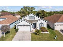 Charming one-story home featuring a well-manicured lawn, attached two-car garage, and inviting curb appeal at 1056 Royal Saint George Dr, Orlando, FL 32828