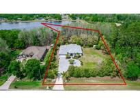 Aerial view of a single-story home on large lot, surrounded by trees and a lake nearby at 19261 Quarterly Pkwy, Orlando, FL 32833