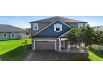 Charming two-story home showcasing a well-manicured front lawn, a two-car garage, and a welcoming front porch at 2383 Regency Park Dr, Deland, FL 32724