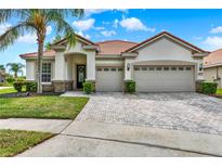 Stunning single-story home boasting a well-manicured lawn, a red tile roof, and a convenient three-car garage at 2843 Maria Isabel Ave, Ocoee, FL 34761