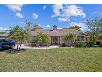 Charming single-story home featuring a well-maintained lawn and inviting red double-door entrance at 353 Wekiva Cove Rd, Longwood, FL 32779