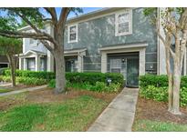 Charming two-story townhome featuring well-maintained landscaping, a welcoming entrance, and mature trees at 3664 Wilshire Way Rd # 261, Orlando, FL 32829