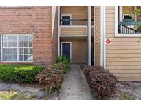 Exterior view of a two-story apartment building with brick and siding and well-maintained landscaping at 4355 Perkinshire Ln # 103, Orlando, FL 32822