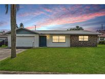 Charming single-story home featuring a well-manicured lawn and eye-catching stone accents at 10900 Tangora St, Orlando, FL 32825