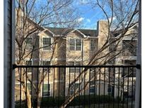 Exterior view from the balcony shows a multi-story condo with large windows, a chimney, and a view of trees at 1990 Erving Cir # 305, Ocoee, FL 34761
