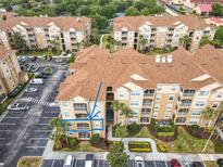 Scenic aerial view of condo with parking, landscaping, and exterior showing private balcony with tropical landscaping at 2781 Almaton Loop # 203, Kissimmee, FL 34747