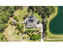 Expansive property featuring a screened pool, lush landscaping, and a private pond at 5200 Carson St, St Cloud, FL 34771