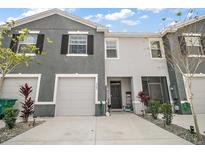 Two-story townhome with a one-car garage and well-maintained landscaping and driveway at 5367 Pinecone Ct, Wildwood, FL 34785