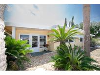Charming home featuring tropical landscaping, a white trim, and neutral yellow siding at 726 Viking Ave, Tavares, FL 32778