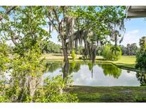 Scenic golf course view featuring a serene pond and lush green fairways, under a bright, sunny sky at 150 Golfside Cir, Sanford, FL 32773