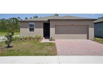 Charming single-story home with a brick driveway and well-maintained lawn and garden at 3218 Viceroy Ct, Poinciana, FL 34759