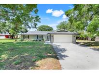Charming single-story home with a well-maintained lawn, mature trees, and a two-car garage at 4570 Chambliss Rd, Winter Haven, FL 33884