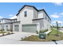 Attractive townhouse with a two-car garage, green space, and a clean, modern aesthetic at 818 Poppy Ln, Dundee, FL 33838