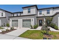 Townhome with well-maintained landscaping, gray two-car garages, and inviting front entrances at 836 Poppy Ln, Dundee, FL 33838
