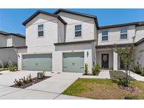 Inviting two-story townhome boasts a well-manicured front yard and attached two-car garage at 848 Poppy Ln, Dundee, FL 33838