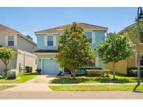 Charming two-story home with a well-maintained lawn, mature trees, and a two-car garage at 8944 Sugar Palm Rd, Kissimmee, FL 34747