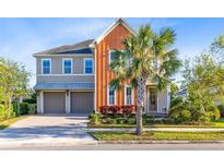 Beautiful two-story home with a two-car garage and a well-manicured lawn, plus a palm tree at 9254 Reymont St, Orlando, FL 32827