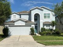 Charming two-story home featuring a well-manicured lawn and an attached two-car garage at 9826 Heron Pointe Dr, Orlando, FL 32832
