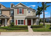Inviting townhouse with red shutters, manicured landscaping, and a charming front porch at 1197 Tallow Rd, Apopka, FL 32703
