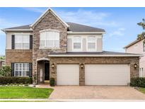 Stunning two-story home featuring a brick facade, stone accents, and a welcoming three-car garage and paver driveway at 1638 Swallowtail Ln, Sanford, FL 32771