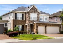 Beautiful two-story home with a brick and stone facade and a three-car garage on a sunny day at 1638 Swallowtail Ln, Sanford, FL 32771