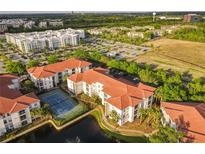 Stunning aerial view of condo complex with tennis court, landscaping, parking, and a beautiful water feature at 2615 Maitland Crossing Way # 9 307, Orlando, FL 32810