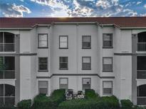 Three-story exterior of building shows multi-pane windows, white siding and a red tile roof at 2615 Maitland Crossing Way # 9 307, Orlando, FL 32810